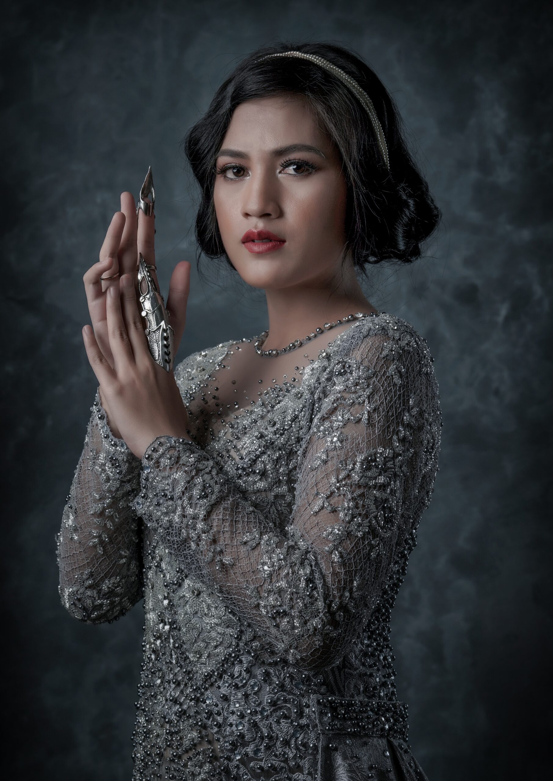 a woman in a silver dress holding a cell phone